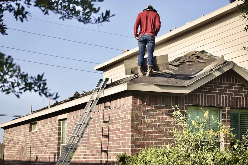 Professional roofer working on a residential roof in Strickland